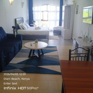 a living room with a couch and a table at See breeze sweets villa in Diani Beach