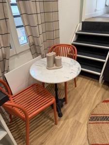 a table with two chairs and a table with mugs on it at Duplex T2 cosy - Hyper Centre - Parking privé in Bourges +8 photos