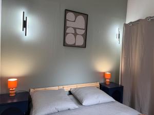 a bedroom with two beds and two lights on the wall at Duplex T2 cosy - Hyper Centre - Parking privé in Bourges