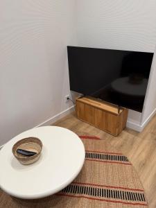 a white toilet in a room with a tv at Duplex T2 cosy - Hyper Centre - Parking privé in Bourges