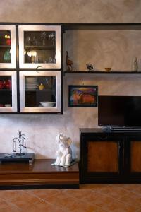 a living room with a television and a table with a statue at Via della Musica in Vicchio
