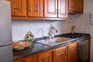 a kitchen with wooden cabinets and a sink and a counter top at Via della Musica in Vicchio