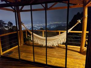 a hammock on a deck with a view of the city at Lunanueva in Cali