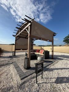 a pavilion with a couch and a bench in the desert at The Perrys Chateau in Old Harbour
