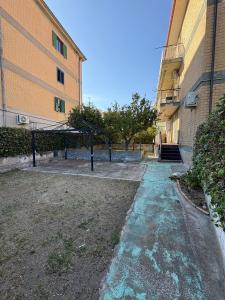 an empty alley between two buildings with a tree at Home Marí in Sessa Aurunca