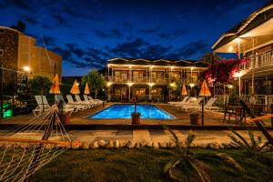 a hotel with a swimming pool in front of a building at Fii Suites in Kumluca