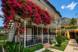 a house with pink flowers on the side of it at Fii Suites in Kumluca