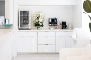 a white kitchen with a counter with a refrigerator at Palm Breeze Hotel in Lake Worth
