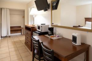 a hotel room with a table and a microwave at Palm Breeze Hotel in Lake Worth