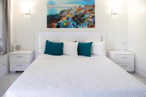 a bedroom with a large white bed with blue pillows at Palm Breeze Hotel in Lake Worth +42 photos