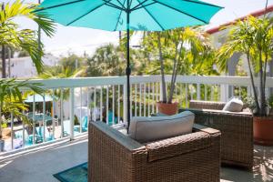 a wicker chair and umbrella on a porch at Palm Breeze Hotel in Lake Worth