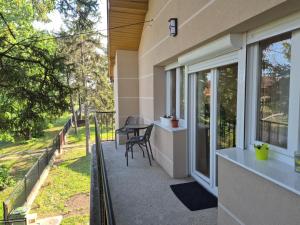 a balcony of a house with a table and chairs at Stan na dan Banovci in Stari Banovci