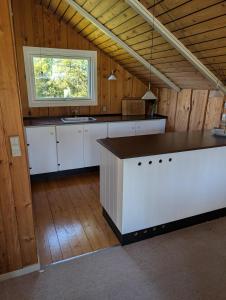 a large kitchen with white cabinets and a window at Marielyst Summer House in Bøtø By +22 photos