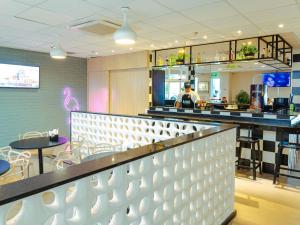 a restaurant with a counter and a bar at ibis Styles Goiania Marista in Goiânia
