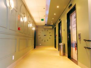 a hallway with a large clock on the wall at ibis Styles Goiania Marista in Goiânia +113 photos