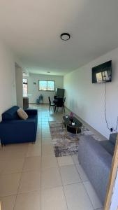 a living room with a blue couch and a table at Departamento scorpio in Tuxtla Gutiérrez