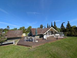 a house with a wooden deck in the yard at Marielyst Summer House in Bøtø By