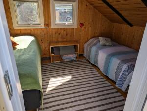 a room with two beds and a tv in a cabin at Marielyst Summer House in Bøtø By