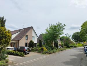 a street with houses and cars parked on the street at VolopVeluwe in Ermelo