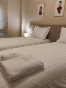 two beds with towels on them in a bedroom at Stay Central 2 in Ioannina