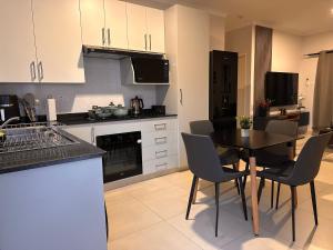 a kitchen with a table and chairs in a kitchen at Moonlight Apartment in Gaborone