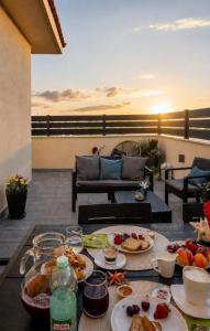 a table with plates of food on a patio at Alba Stays in Ladispoli
