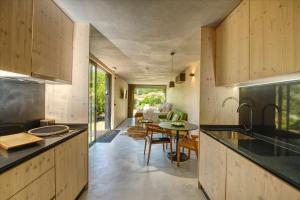 a kitchen with wooden cabinets and a table in a room at Riverside Lodges - Serra da Estrela - Chão da Ribeira in Gouveia
