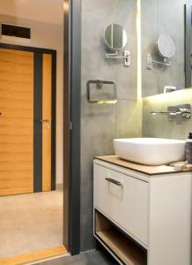a bathroom with a white sink and a mirror at Vila Golija StudiovetKop in Kopaonik