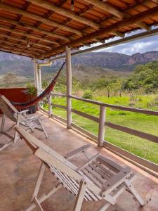 a hammock and chairs on a porch with a view at Pouso do Elefante in Serra do Cipo