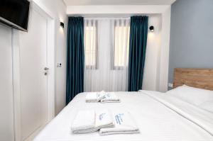 a bedroom with a bed with two towels on it at Apartments NOCE - Premium Lake View in Ohrid