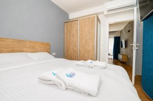 a bedroom with a white bed with towels on it at Apartments NOCE - Premium Lake View in Ohrid