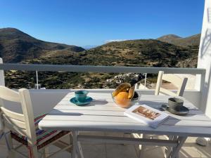 a table with a bowl of fruit on a balcony at Vorino house in Amorgos