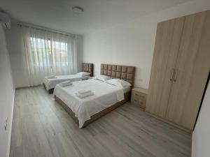 a bedroom with two beds and a large window at Golem Apartments in Golem