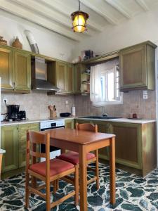 a kitchen with green cabinets and a wooden table and chairs at Vorino house in Amorgos