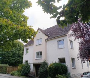 a white house with a brown roof at Ferienwohnung am Kurwald, Nähe Kliniken, 88qm, Parkplatz in Bad Lippspringe