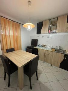a kitchen with a wooden table and some chairs at sunny Podaca in Podaca