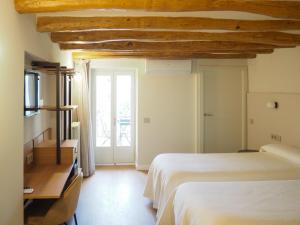 a bedroom with a bed and a window at Hotel Tall de Conill in Capellades