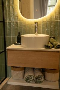 a bathroom with a sink and towels on a shelf at Le Castelas - Suite Calisson in Aurons +21 photos