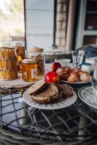 a table topped with plates of bread and apples and jam at Le Castelas - Suite Calisson in Aurons