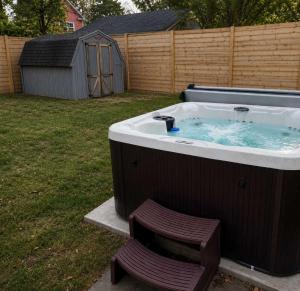 a hot tub with a chair in a yard at Walk to Highland Square, Sleeps 8 in Akron