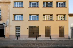 a yellow building with doors and windows at Madero By Homirent in Querétaro