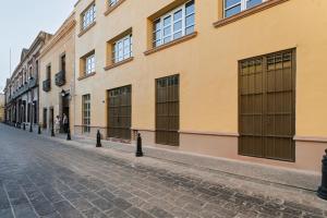 a cobblestone street in front of a building at Madero By Homirent in Querétaro