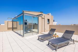 two chairs on the patio of a house at Raise Porta Nuova in Heraklio