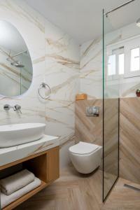 a bathroom with a sink and a glass shower at Niriides in Porto Koufo +111 photos