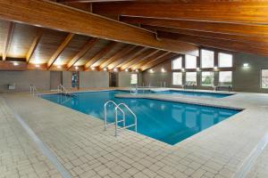 a large swimming pool with blue water in a building at AmericInn by Wyndham Appleton North Little Chute in Appleton