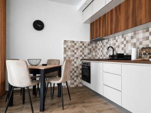 a kitchen with a table and chairs in a kitchen at Apartman Nati in Banja Koviljača +4 photos