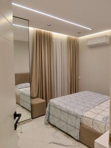 a bedroom with a bed and a mirror at Marbel Sea View in Shëngjin