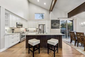 a kitchen with white cabinets and a large island with stools at Chalet Near The Tahoe Keys in South Lake Tahoe