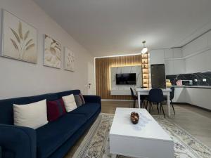 a living room with a blue couch and a table at Cozy Pogradec up in Pogradec