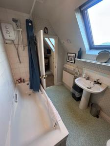 a bathroom with a bath tub and a sink at Walsingham Bakehouse in Little Walsingham